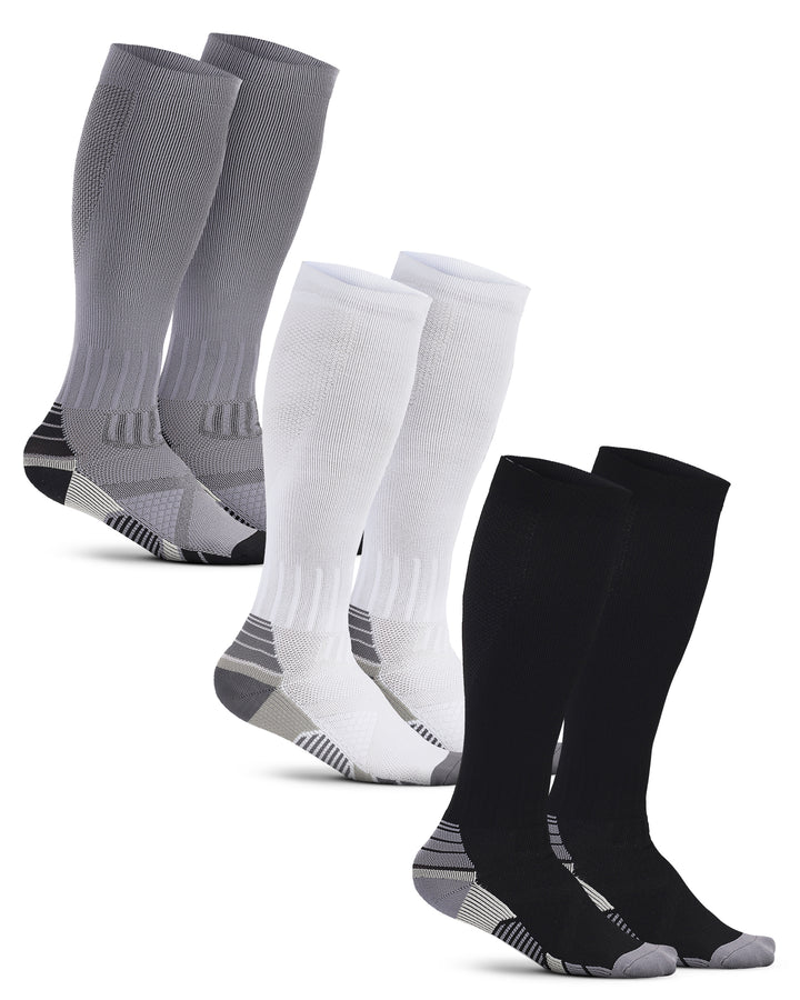 Set of gray, white, and black knee-high socks on a white background