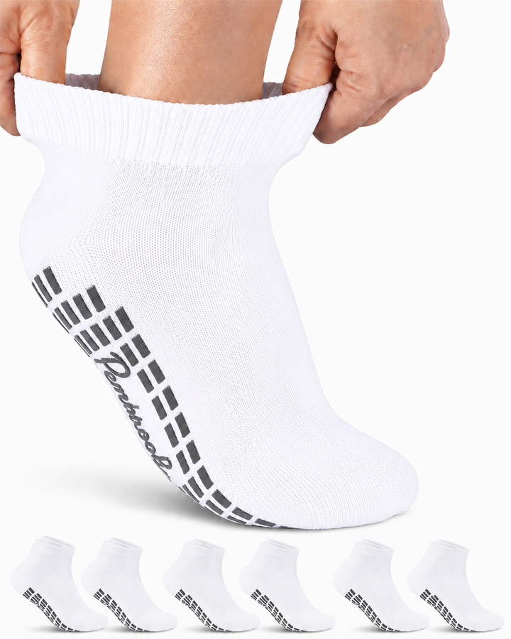 Set of white socks with black branding held by a person on a white background