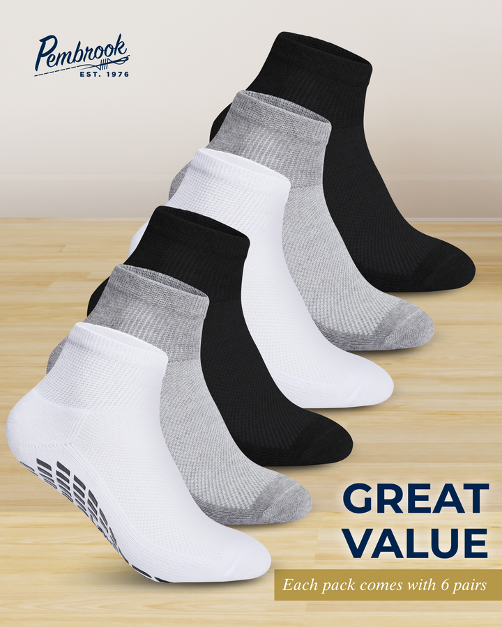 Set of six pairs of black, gray, and white socks on a wooden surface with &