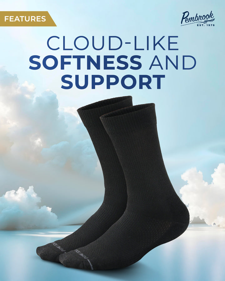 Black socks with cloud-like softness and support text on a blue sky background