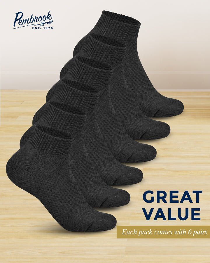 Six pairs of black socks on a wooden surface with &