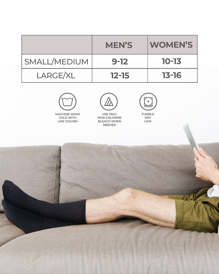 Person wearing black socks on a couch with size chart and care instructions.